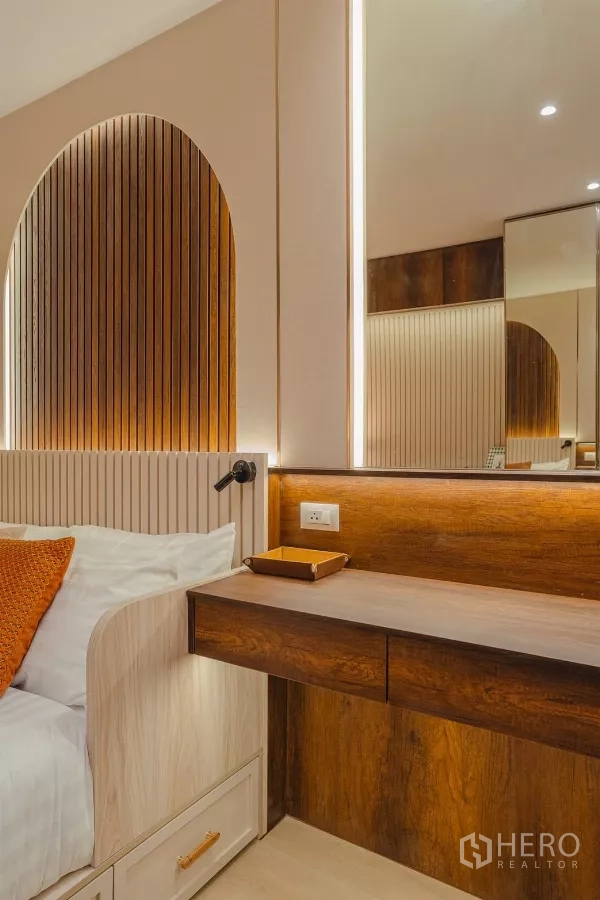 Condominium for rent in Yan Nawa, Bangkok - Close-up of built-in wooden desk beside the bed with soft LED strip lighting.