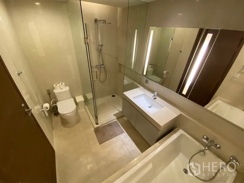 公寓 出租或出售在Watthana, Bangkok - 现代卫浴，玻璃淋浴间、浴缸、大镜面与洗手台。