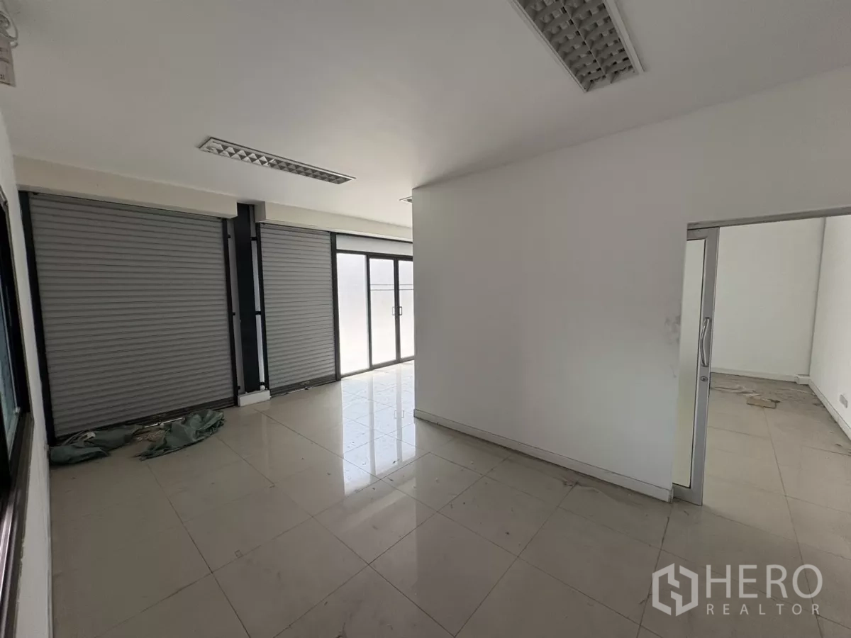 Warehouse for rent in Bang Phli, Samut Prakan - Ground-floor office area with tiled floor, roller shutters and glass entry.