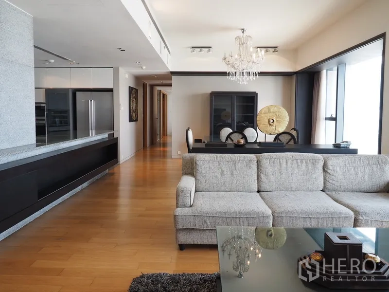 คอนโด ให้เช่าในSathon, Bangkok - พื้นที่นั่งเล่นกว้าง โซฟาสีเทา ชุดโต๊ะอาหาร และตู้บิลต์อินสำหรับทีวีข้างหน้าต่างบานใหญ่