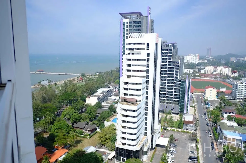 Condominium for rent or sale in Si Racha, Chon Buri - High-floor city and sea view over Si Racha skyline with nearby towers, coastline and greenery.