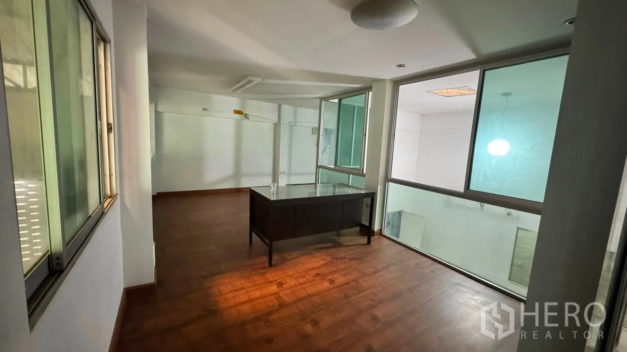 Warehouse for rent in Bang Khen, Bangkok - Mezzanine office area with large windows and a desk overlooking the warehouse floor.