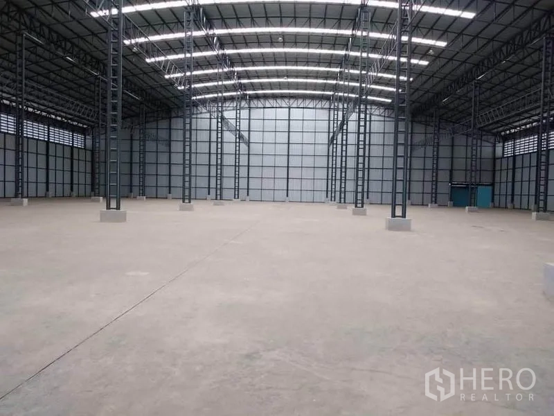 工厂 出租在Mueang Samut Prakan, Samut Prakan - 仓库中央通道，面向远端墙面，顶部为多排天窗与LED灯带。