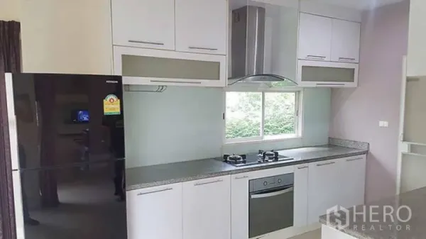 Detached House for rent in Saphan Sung, Bangkok - Fitted kitchen with white cabinetry, gas hob, oven, range hood, and large refrigerator.