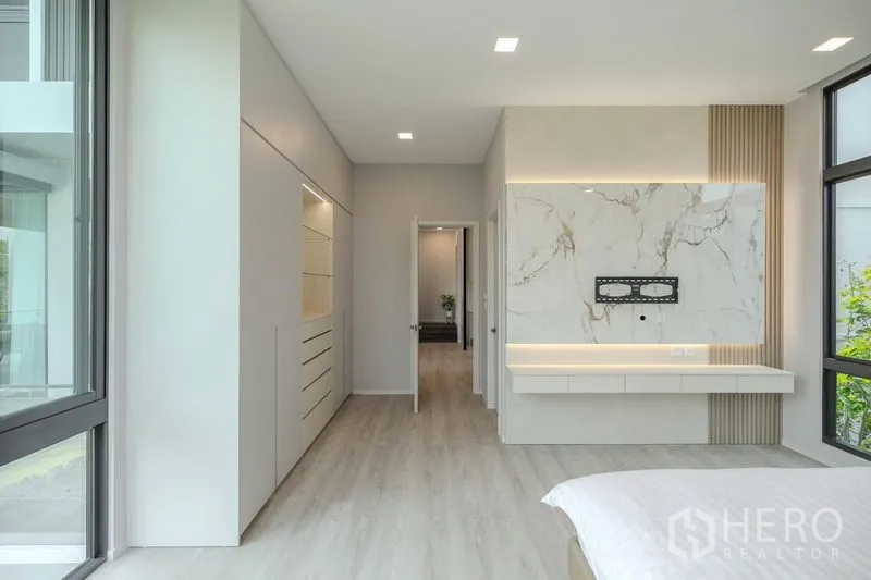 Detached House for rent in Saphan Sung, Bangkok - Bedroom view toward built-in closets and marble feature wall.