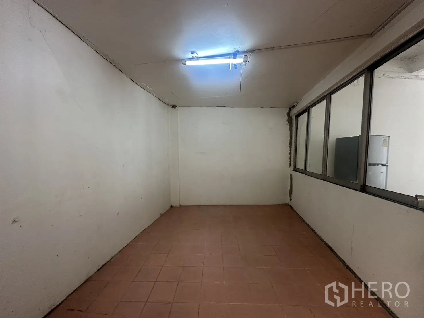 Home Office for rent in Watthana, Bangkok - Enclosed room with tiled floor and a long internal window beside the partition.