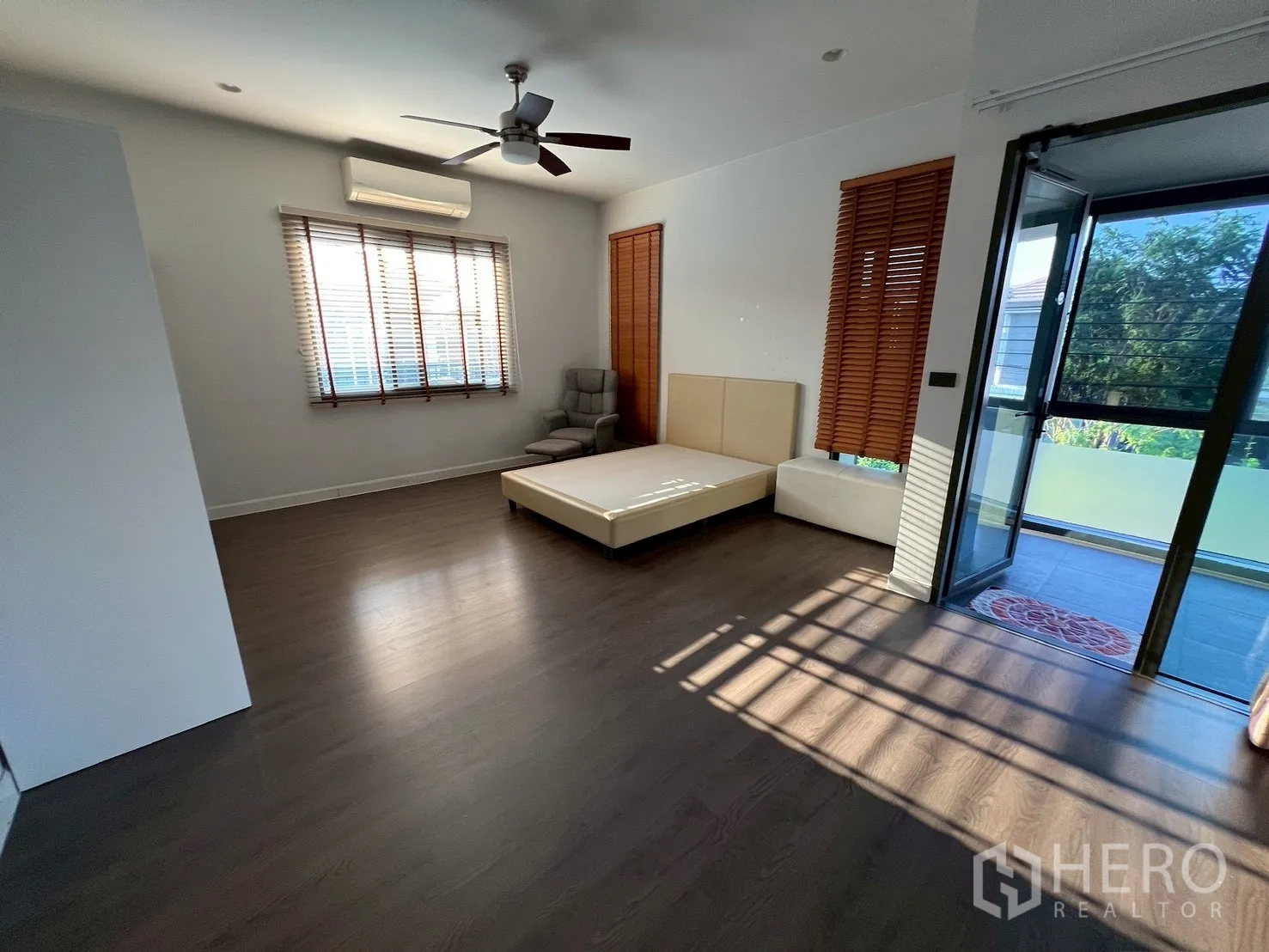 独栋房屋 for rent in Bang Kapi, Bangkok - 宽敞主卧，带平台床、躺椅，并可通往玻璃封闭阳台。