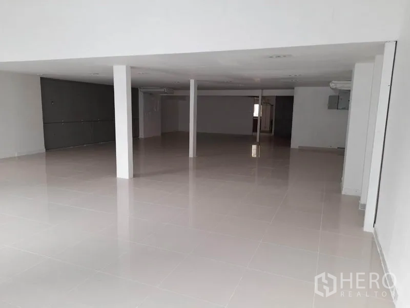 零售空间 出租在Ratchathewi, Bangkok - 开间式零售室内，亮面瓷砖地、白色立柱与嵌入式照明。