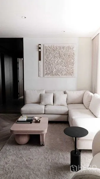 คอนโด ขายในRatchathewi, Bangkok - มุมห้องนั่งเล่น โซฟาสีครีมและงานศิลป์ตกแต่งผนัง