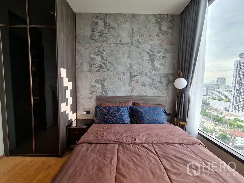 Condominium for rent - Primary bedroom with stone accent wall, floor-to-ceiling window and city skyline view.