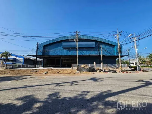 Factory for rent in Chon Buri - Front facade of a large arched-roof warehouse with ventilation louvers facing the street.