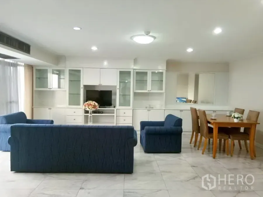 คอนโด ให้เช่าในWatthana, Bangkok - โซนนั่งเล่นและทานอาหาร เปิดโล่ง ตู้บิลท์อินสีขาว โซฟาสีน้ำเงิน และไฟดาวน์ไลท์