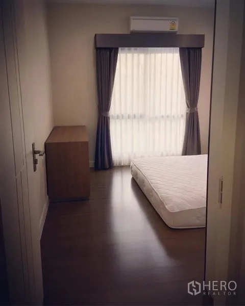 บ้าน ขาย - ห้องนอนอบอุ่น มีผ้าม่าน เครื่องปรับอากาศ และที่นอนต่ำ
