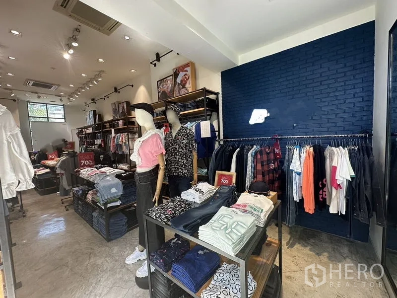 พื้นที่ขายปลีก ให้เช่าในPhra Khanong, Bangkok - โซนแสดงสินค้า ผนังสีกรมท่าพร้อมไฟส่อง ชั้นวางของ และหุ่นโชว์ ภายในร้านที่สะอาด