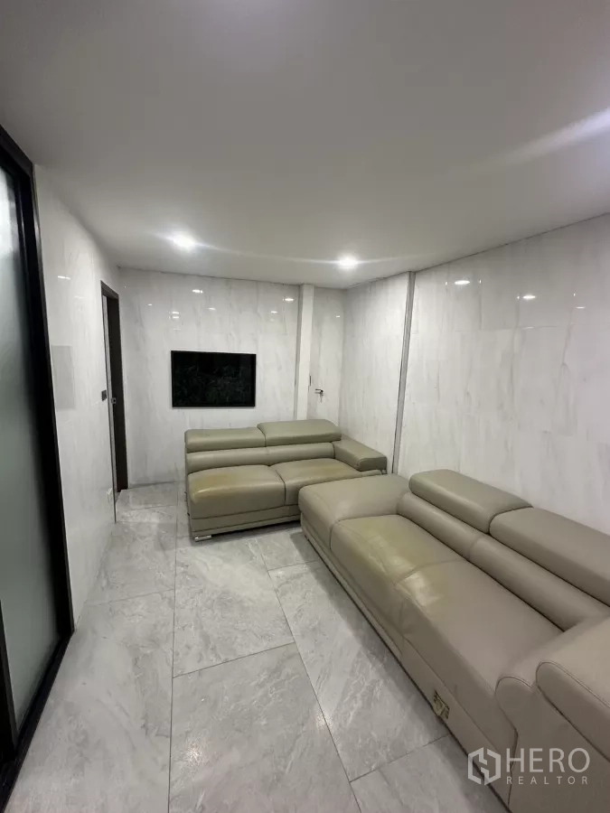 零售空间 出租在Watthana, Bangkok - 会客区，两个皮沙发与嵌灯，地面铺砖