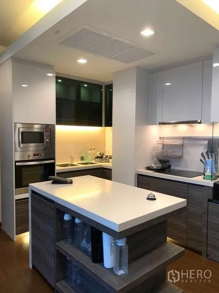 Condominium for rent or sale in Huai Khwang, Bangkok - Contemporary kitchen with an island, built-in oven, and under-cabinet lighting.