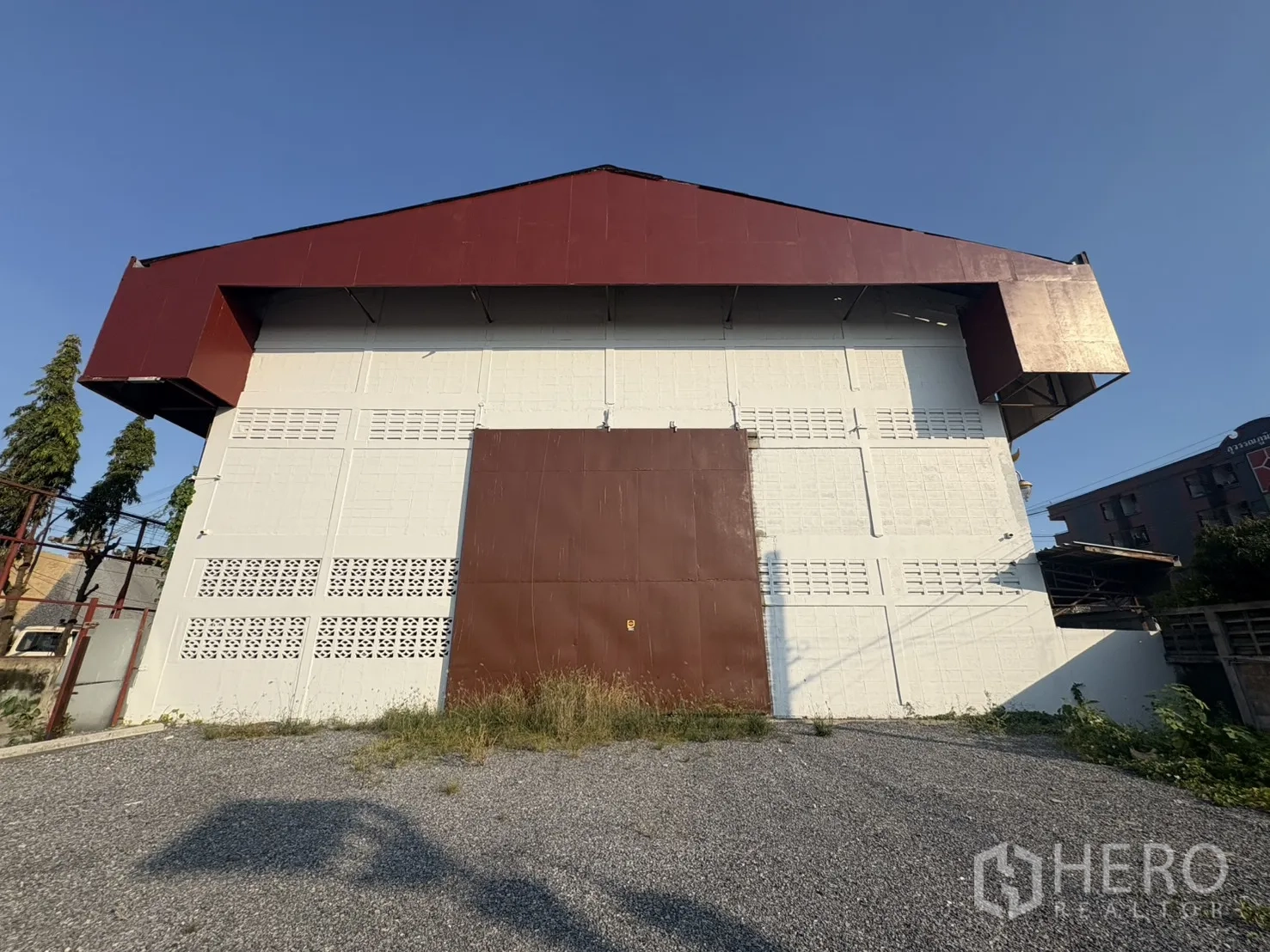 คลังสินค้า ให้เช่าในBang Phli, Samut Prakan - ด้านหลังโกดังพร้อมประตูเหล็กบานใหญ่และลานกรวด