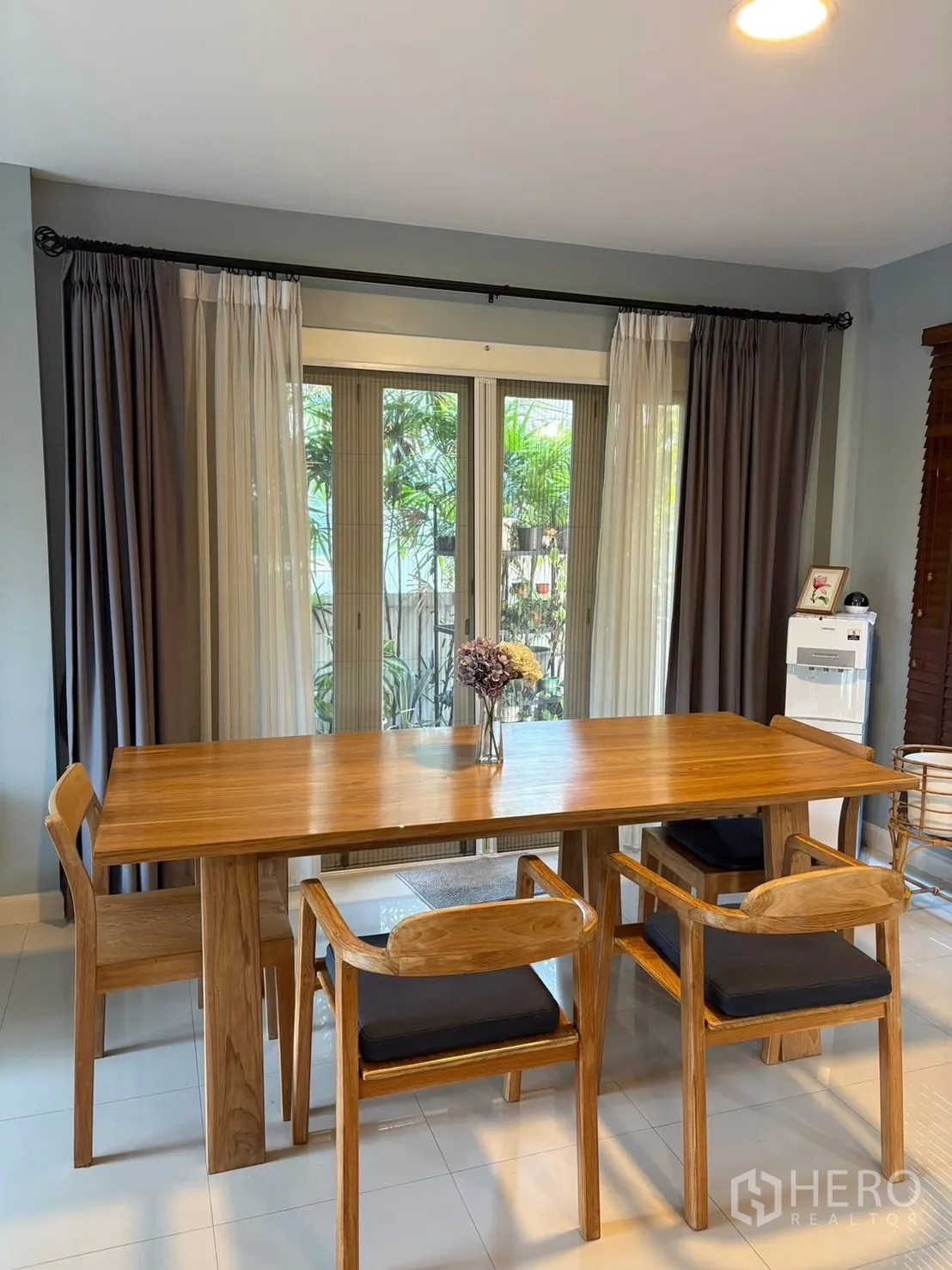 独栋房屋 for rent in Prawet, Bangkok - 餐厅设木质餐桌与落地玻璃门通向花园。