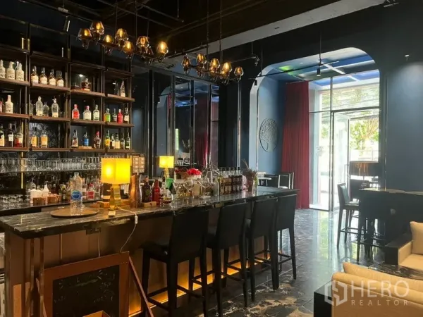 零售空间 出租在Watthana, Bangkok - 精装零售空间，设大理石吧台、背柜酒架与吊灯，高脚椅及临街玻璃入口，展示效果醒目。