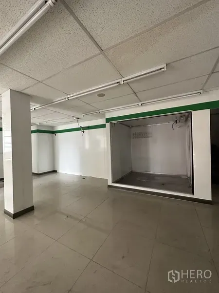 零售空间 出租在Khlong Toei, Bangkok - 明亮的瓷砖开放空间，方格吊顶灯，带凹入式展示区。