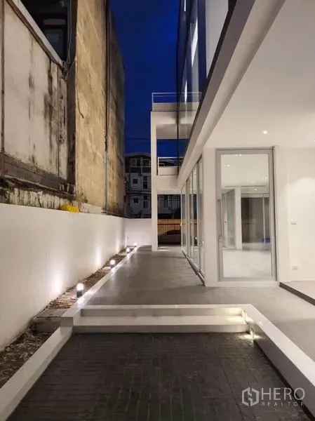 สำนักงานที่บ้าน ให้เช่าในYan Nawa, Bangkok - ทางเดินข้างอาคารยามค่ำ พร้อมไฟสนามและประตูกระจก