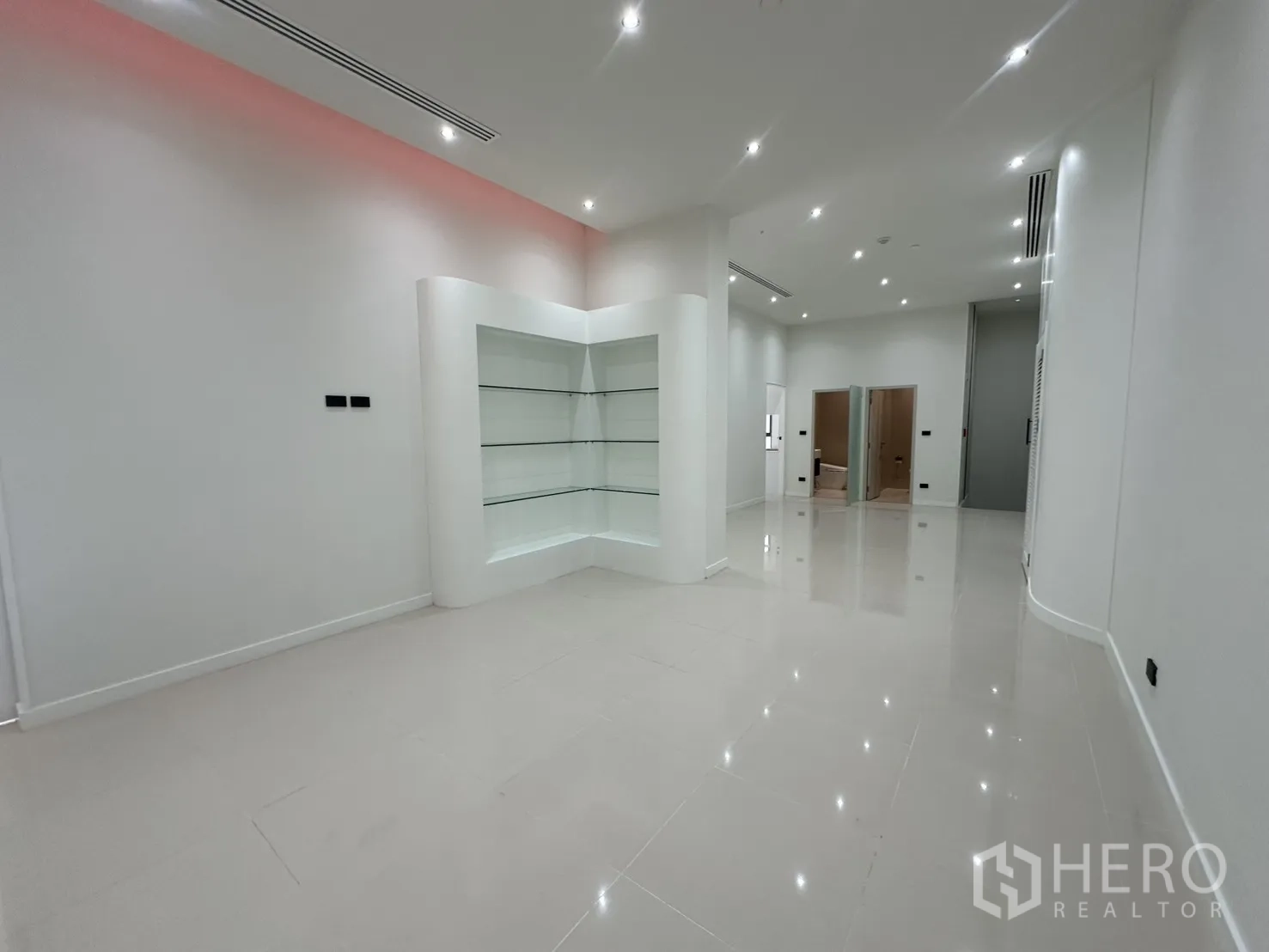 零售空间 出租 - 白色展厅，带发光转角展示柜。