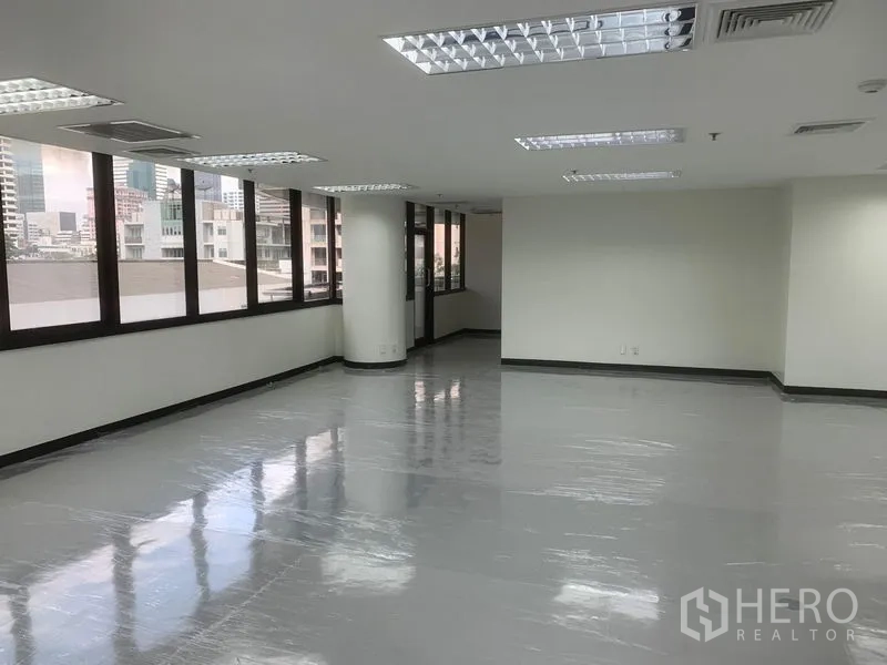 办公空间 出租在Bang Rak, Bangkok - 办公室侧翼空间明亮，多扇窗户与天花灯具，视野开阔。