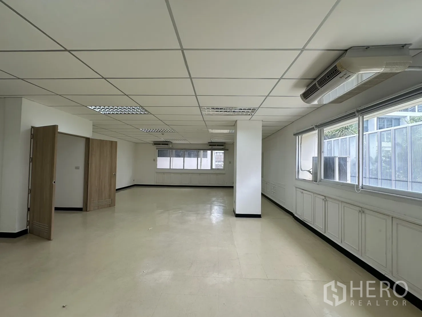 ออฟฟิศ for rent in Pathum Wan, Bangkok - พื้นที่ทำงานยาวมีหน้าต่างบานกว้าง เสากลางห้อง แอร์แขวน และผนังสีขาวตกแต่งบิลต์อิน.