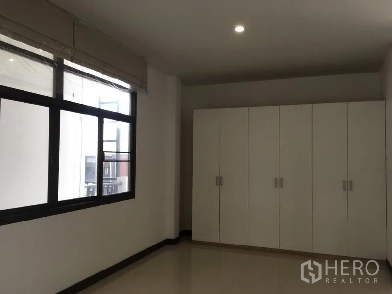 ทาวน์เฮาส์ ให้เช่าในWatthana, Bangkok - ห้องนอนพร้อมหน้าต่างบานใหญ่และตู้เสื้อผ้าบิวท์อินสีขาวทั้งผนัง