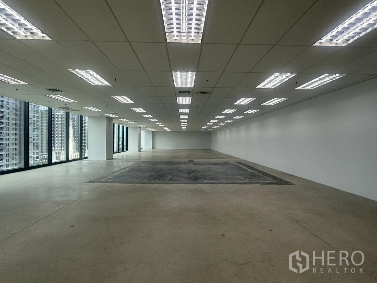 Office Space for rent in Ratchathewi, Bangkok - Long rectangular office zone with rows of fluorescent lights and wall-to-wall windows.