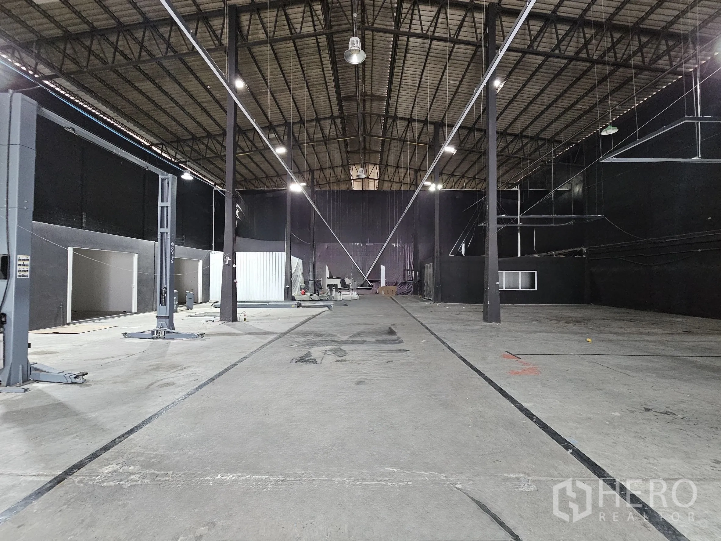 Warehouse for rent in Khlong Toei, Bangkok - Spacious warehouse interior with high roof, steel trusses, concrete floor, and side bays.