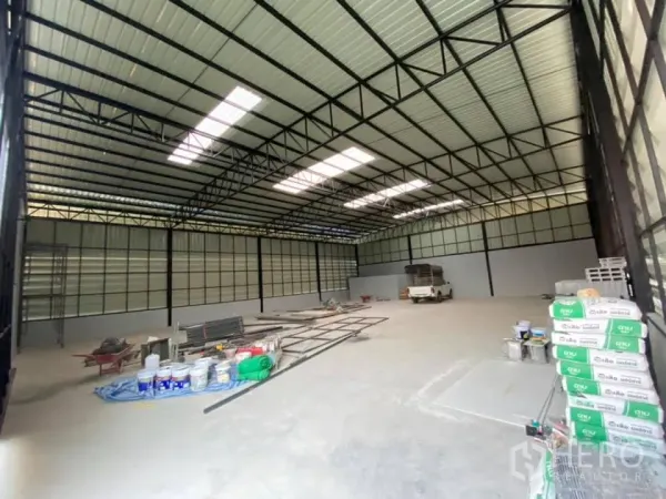 货栈 出租在Saphan Sung, Bangkok - 超大储存大厅，金属屋架配采光板，现场堆放施工物料。