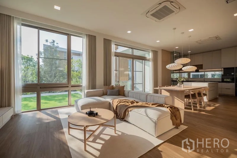 Detached House for rent in Saphan Sung, Bangkok - Open-plan living, dining and island kitchen with large windows facing a private lawn.