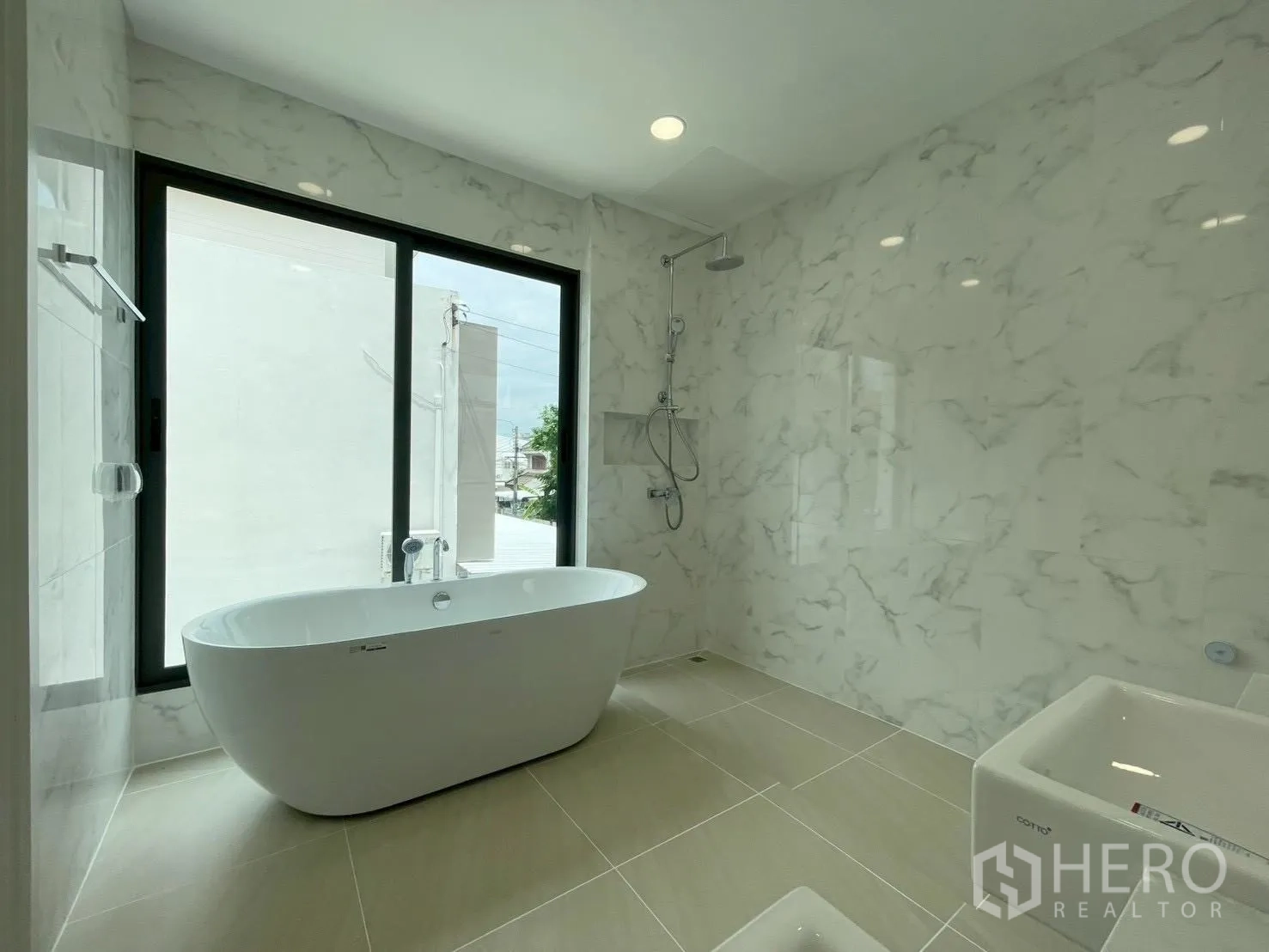 Detached House for sale in Chatuchak, Bangkok - Bright bathroom with a large window, soaking tub, and wall-mounted rain shower.