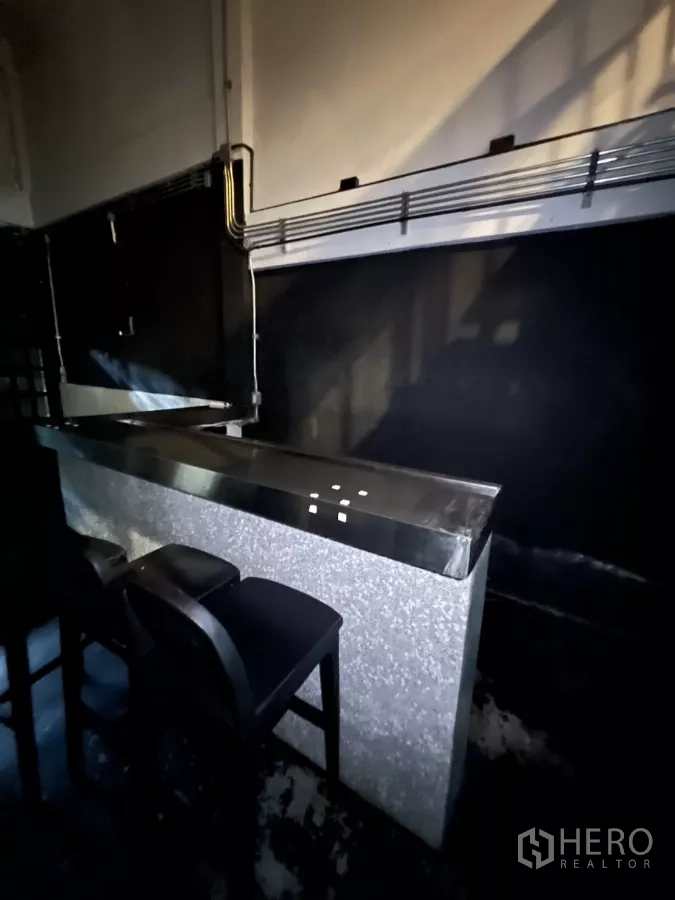 店屋 出租在Watthana, Bangkok - 石纹吧台近景，高脚椅及外露管线。