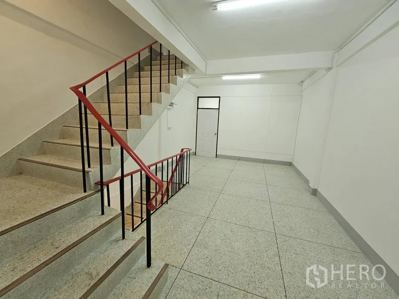 店屋 出租 - 多层混凝土楼梯，红色扶手相连各楼层。