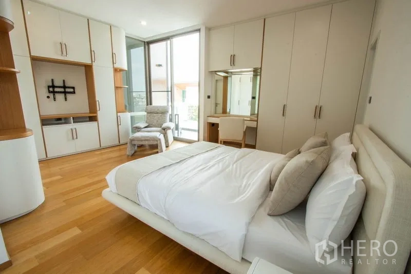 Detached House for sale in Saphan Sung, Bangkok - Bright bedroom with built-in wardrobes, vanity and balcony access.