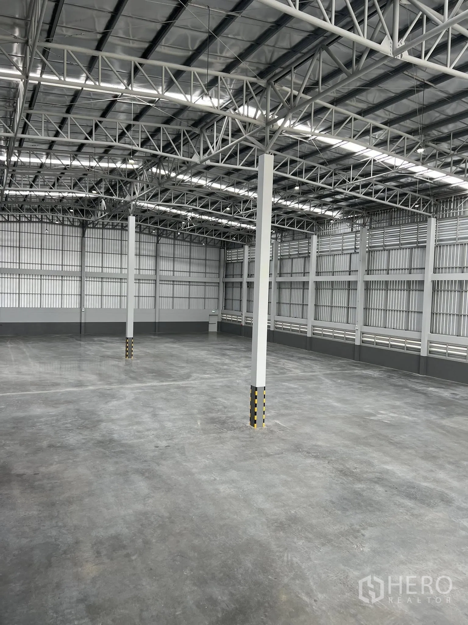 Warehouse for rent in Phra Pradaeng, Samut Prakan - Elevated view of the warehouse interior with structural columns and insulated roof.