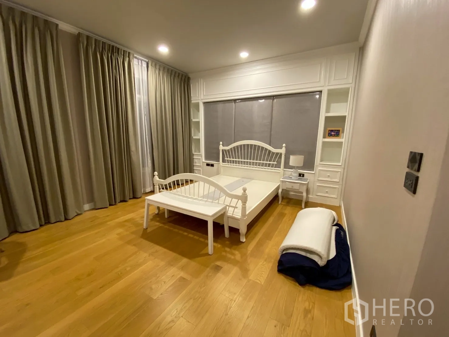 Detached House for sale in Mueang Nakhon Pathom, Nakhon Pathom - Large bedroom with white bed frame, built-in cabinetry and full-length blackout curtains.