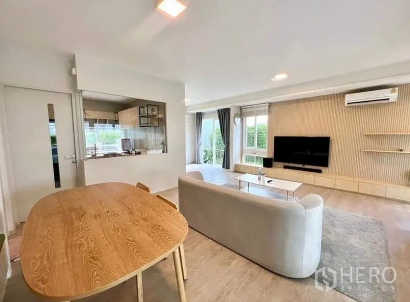 บ้าน ให้เช่า - ห้องนั่งเล่นมีโซฟา ผนังติดทีวี โต๊ะทานข้าว และมองเห็นครัว