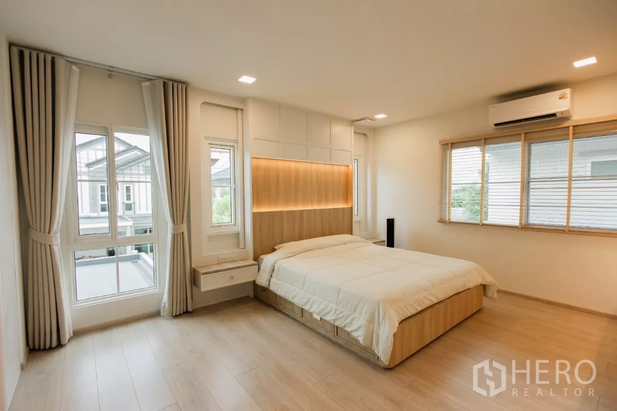 独立式住宅 出租或出售在Bang Phli, Samut Prakan - 主卧配大床，木质灯带床头与大转角窗。