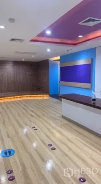 零售空间 出租在Bang Rak, Bangkok - 接待台与木地板，内嵌吊顶照明的零售空间。