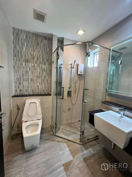 บ้าน ให้เช่าหรือขายในLat Krabang, Bangkok - ห้องน้ำพร้อมตู้กระจกกั้นอาบน้ำ ผนังกระเบื้องโมเสก และสุขภัณฑ์สมัยใหม่