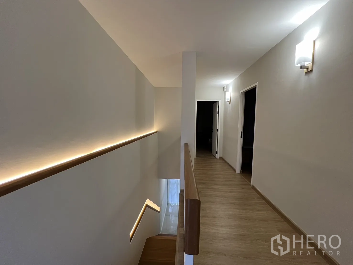 Detached House for rent in Saphan Sung, Bangkok - Upstairs hallway with wood floors and LED strip along the stairs.