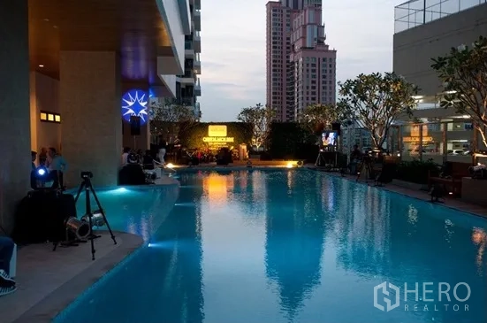 公寓 出租或出售在Khlong Toei, Bangkok - 傍晚时分的公寓室外泳池，城市景观与休憩区。