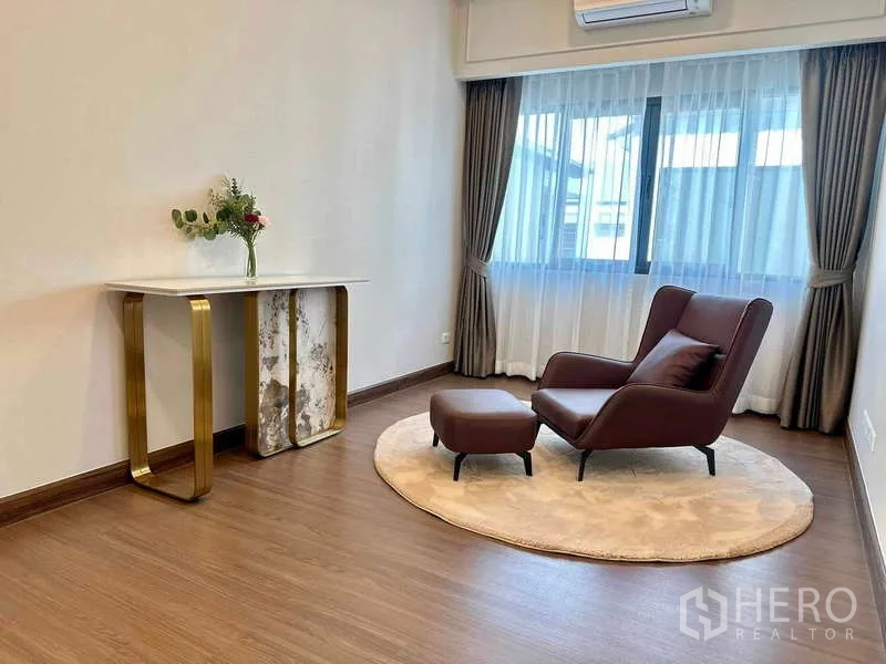 Detached House for rent or sale in Bang Phli, Samut Prakan - Upstairs sitting area with leather lounge chair, ottoman and a wide curtained window.