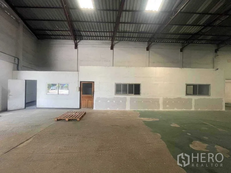 Warehouse for rent in Khlong Toei, Bangkok - Internal office block with windows inside the warehouse next to an open storage area.