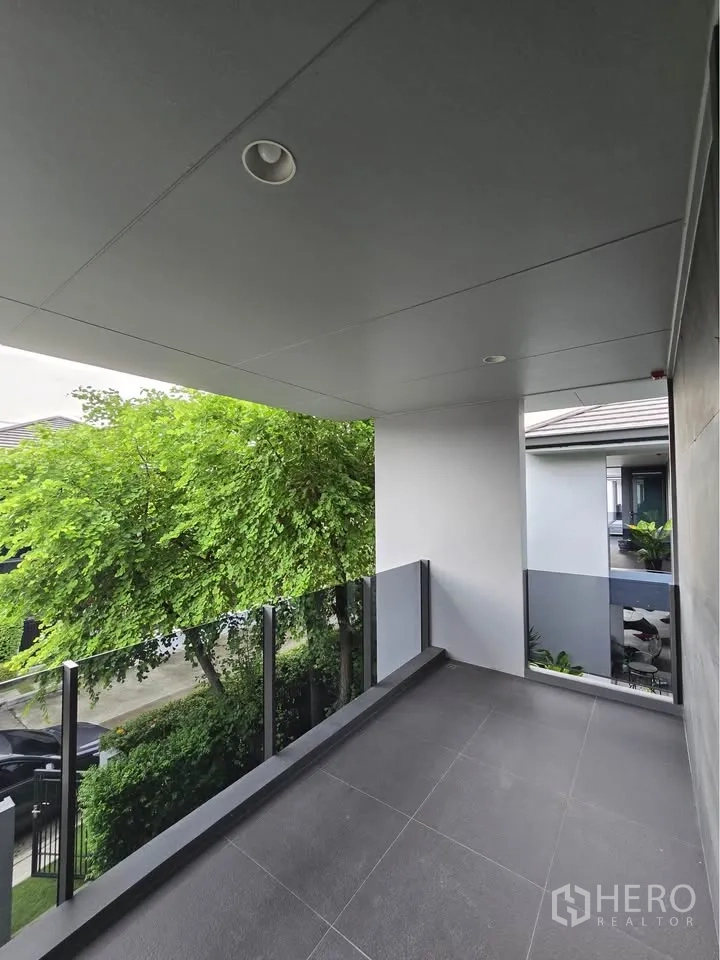บ้านเดี่ยว for rent in Bang Kapi, Bangkok - ระเบียงมีหลังคาพร้อมราวกันตกกระจก มองเห็นต้นไม้