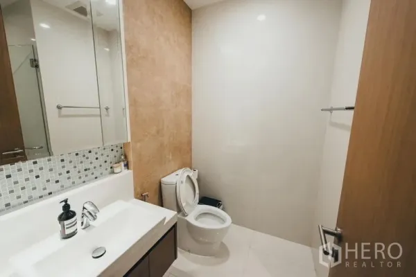 คอนโด ให้เช่าในKhlong Toei, Bangkok - ห้องน้ำแขก อ่างล้างหน้าทรงยาว กระจกบานใหญ่ ผนังโมเสก และโถสุขภัณฑ์