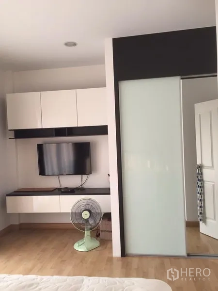 联排别墅 出租或出售在Wang Thonglang, Bangkok - 卧室配壁挂电视与悬空柜，木质地板，磨砂玻璃推拉衣柜门。